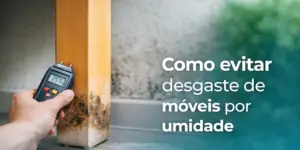 Mão com medidor de umidade apontando 25.7% em móvel danificado por água